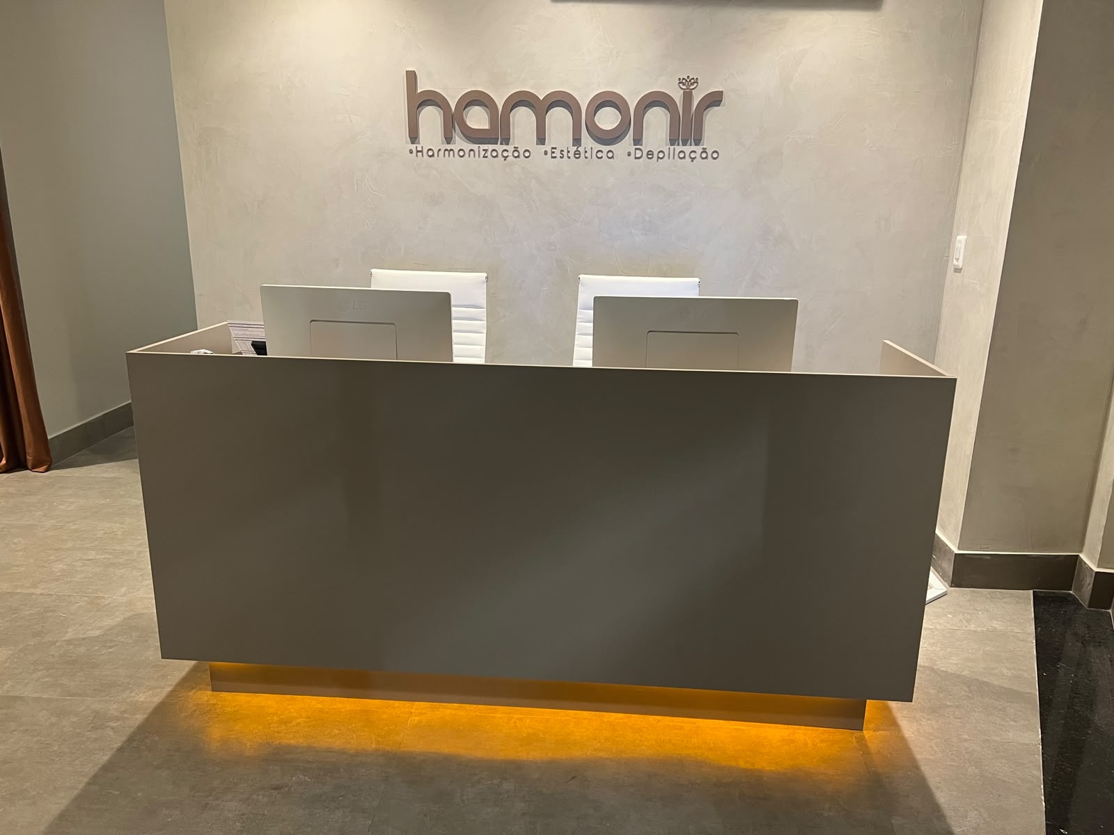 Recepção da Hamonir Campo Grande com logo iluminado na parede